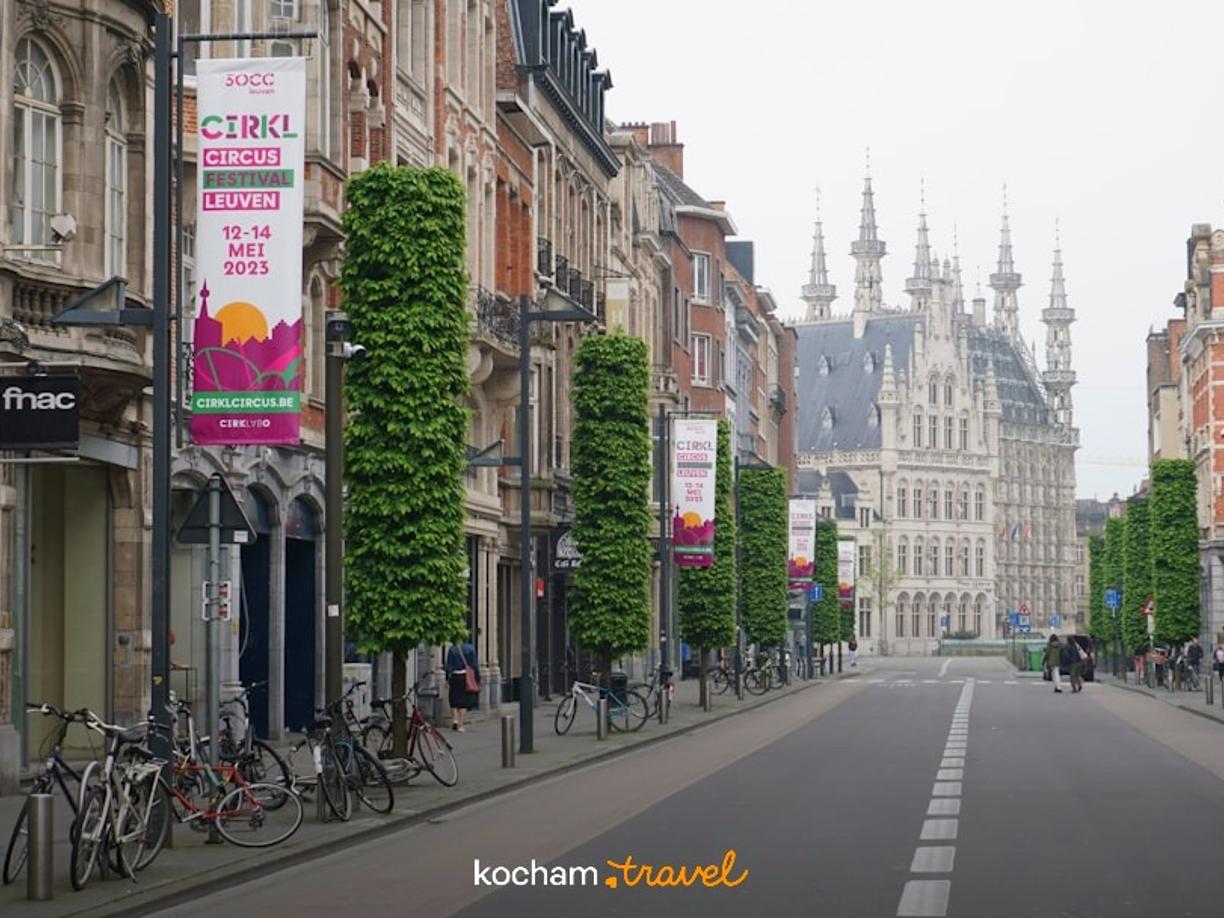 Zabytkowa ulica w Leuven, Belgia, z ratuszem i rowerami.