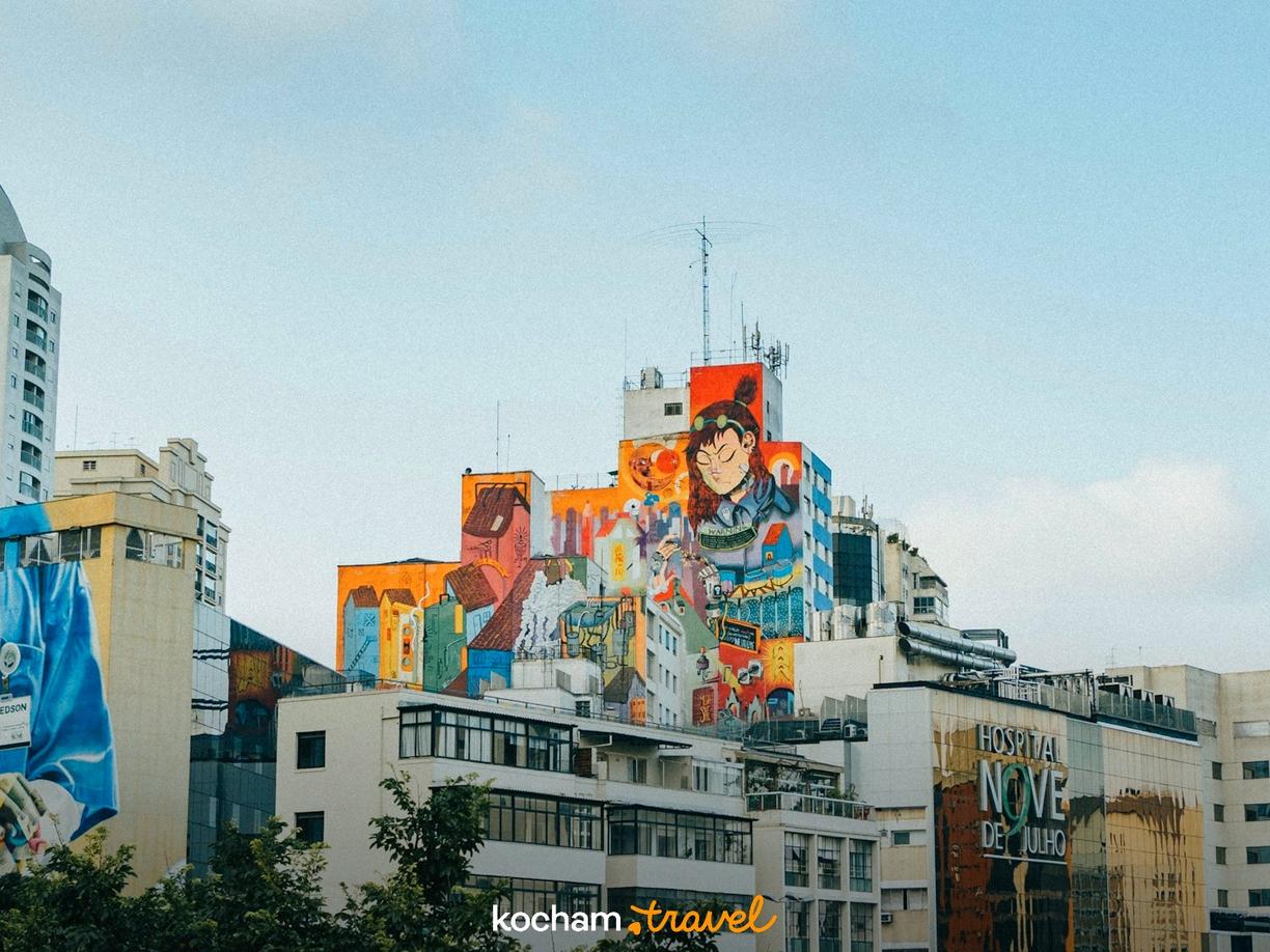 Kolorowe murale na budynkach w mieście, w tym lekarz i postać z anime.