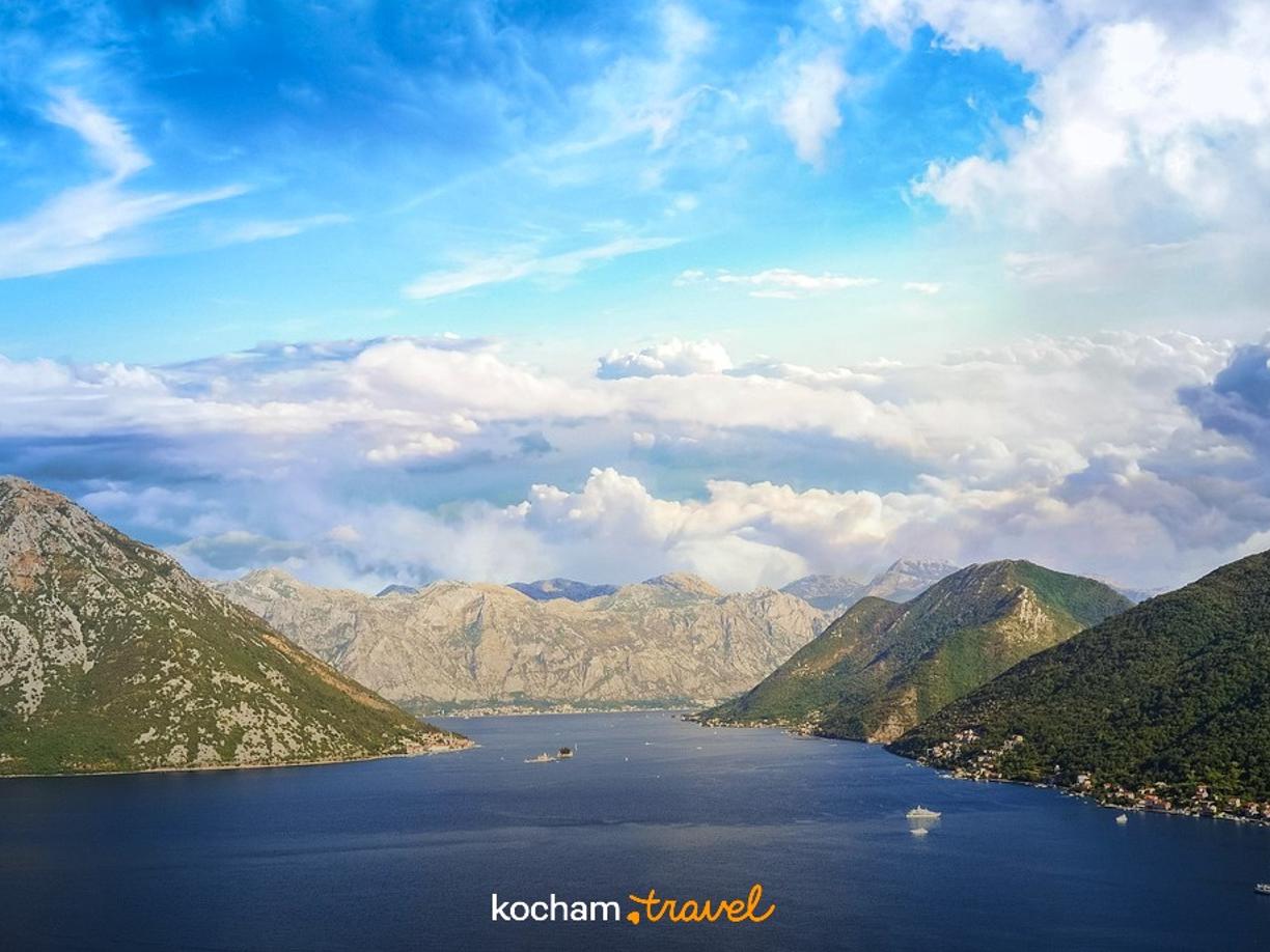 Panoramiczny widok zatoki otoczonej górami, z łodziami na wodzie.
