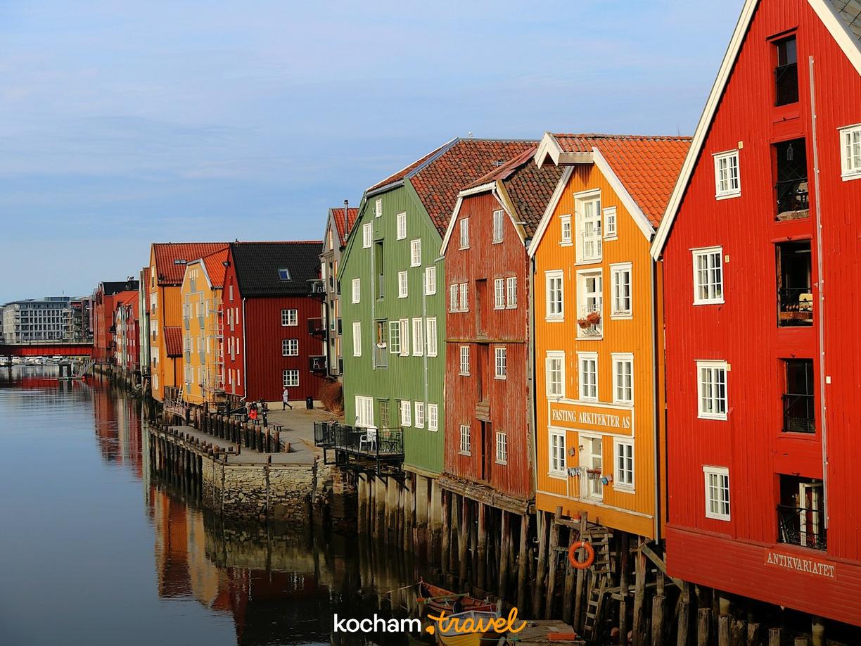 Kolorowe drewniane domy na palach nad rzeką Nidelva w Trondheim.