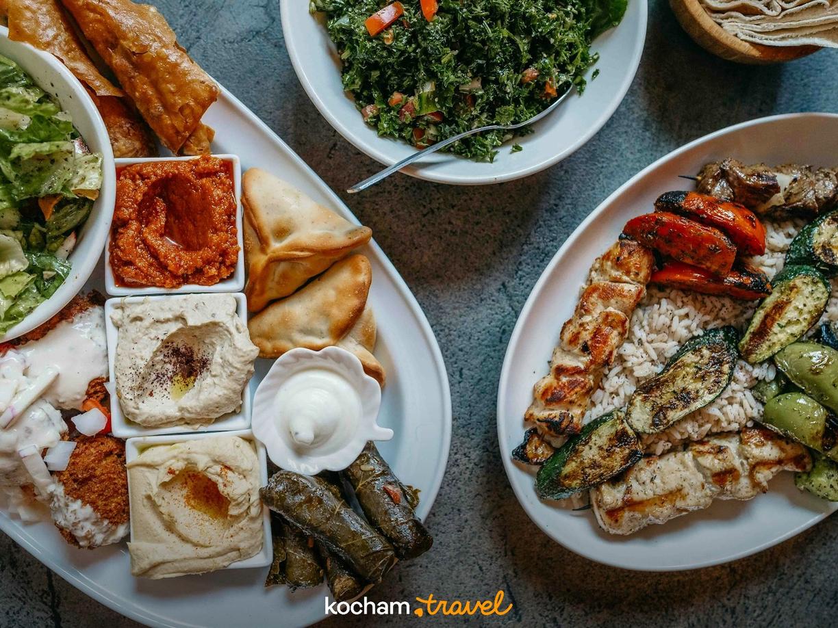 Kolorowe dania kuchni arabskiej: mezze, grillowane mięsa, ryż i sałatki.
