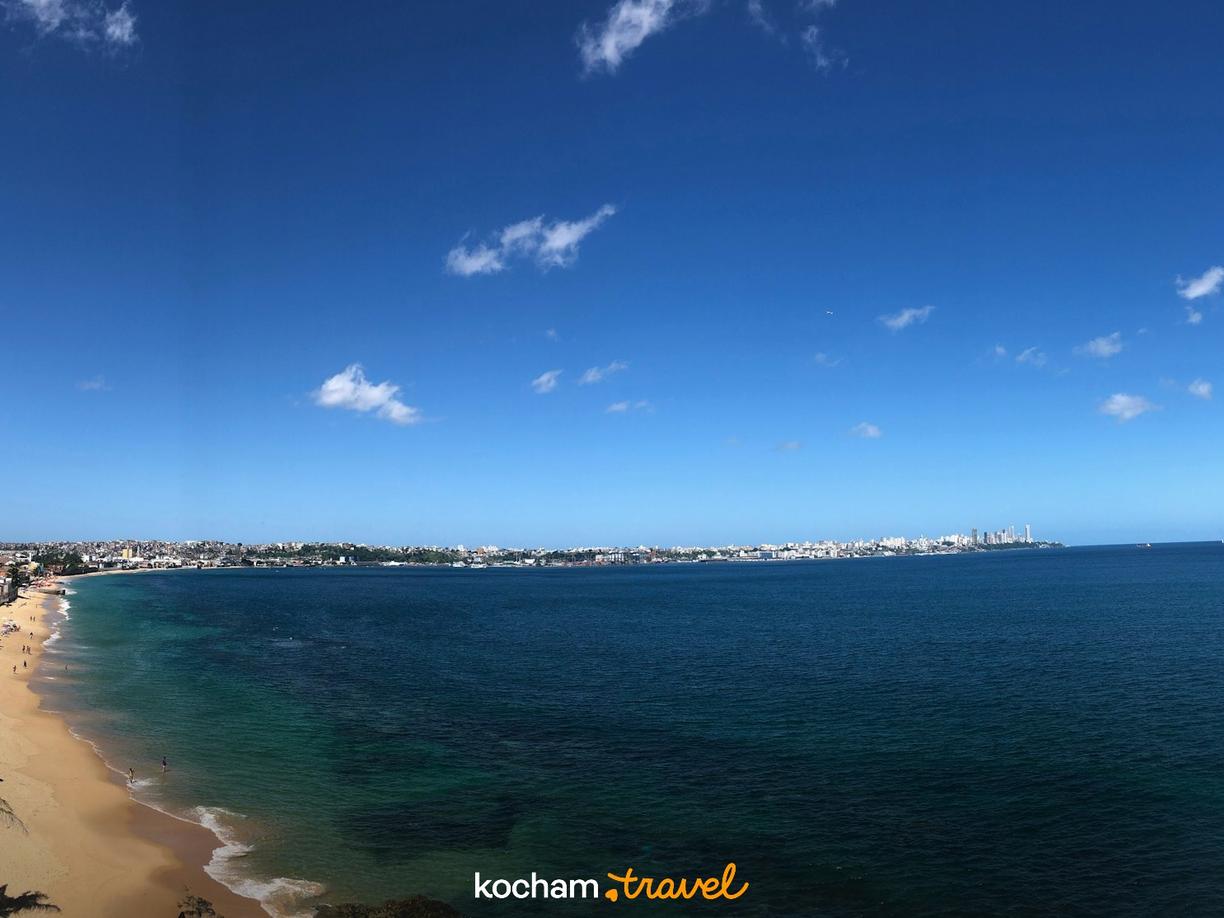 Złota plaża, turkusowy ocean i rozległa panorama miasta.