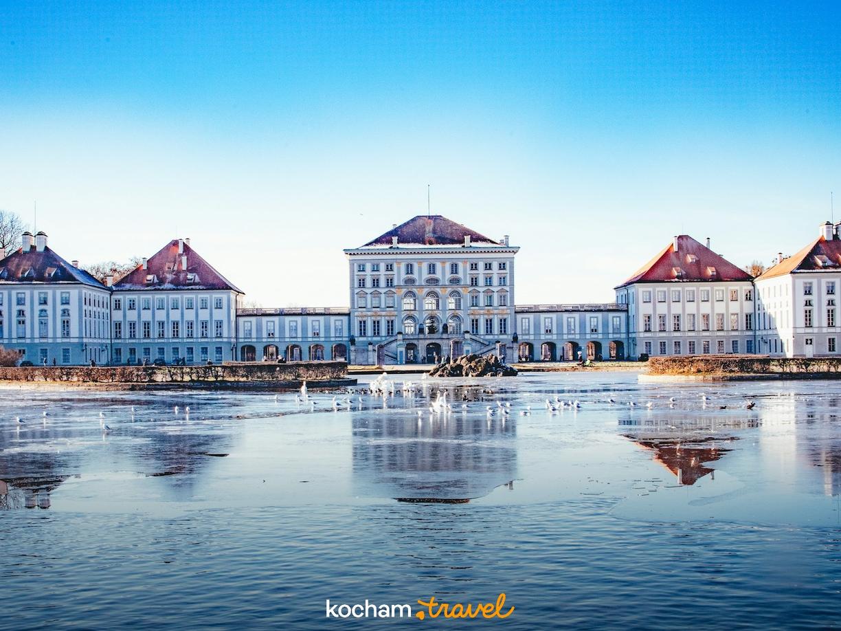 Zimowy Pałac Nymphenburg w Monachium, odbity w zamarzniętym kanale.