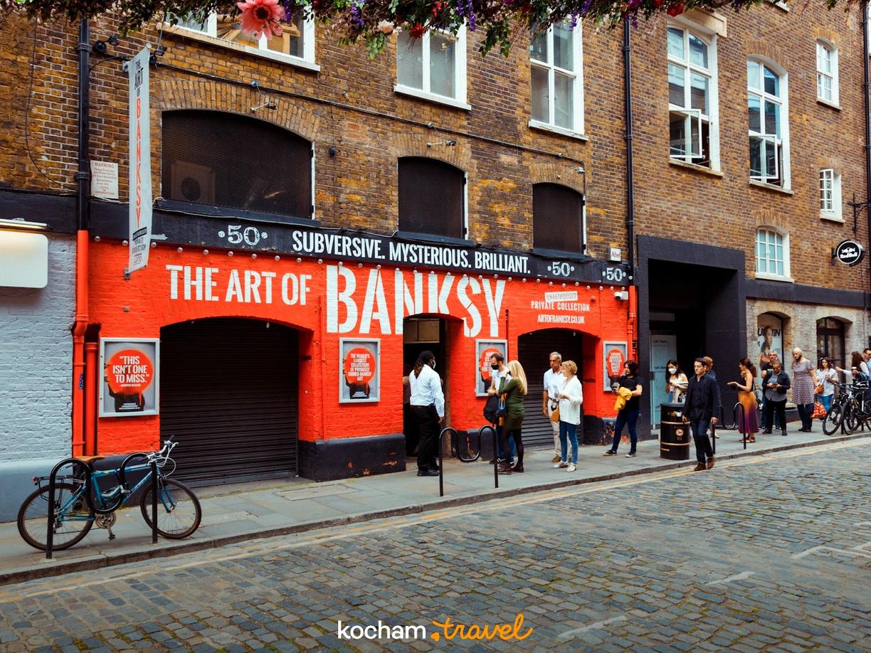 Ludzie przed wystawą The Art of Banksy na londyńskiej ulicy.