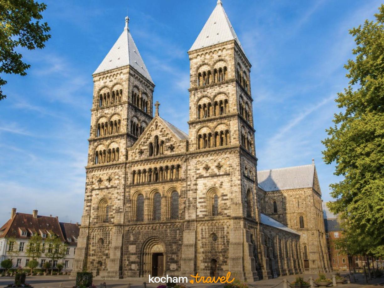 Romańska Katedra w Lund z imponującymi wieżami na tle błękitnego nieba.