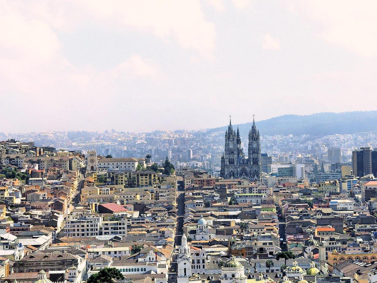 Panoramiczny widok na Quito z gotycką katedrą, starymi budynkami i górami.