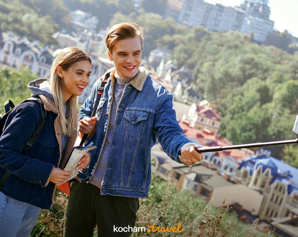 Młoda para turystów robi selfie z widokiem na miasto.