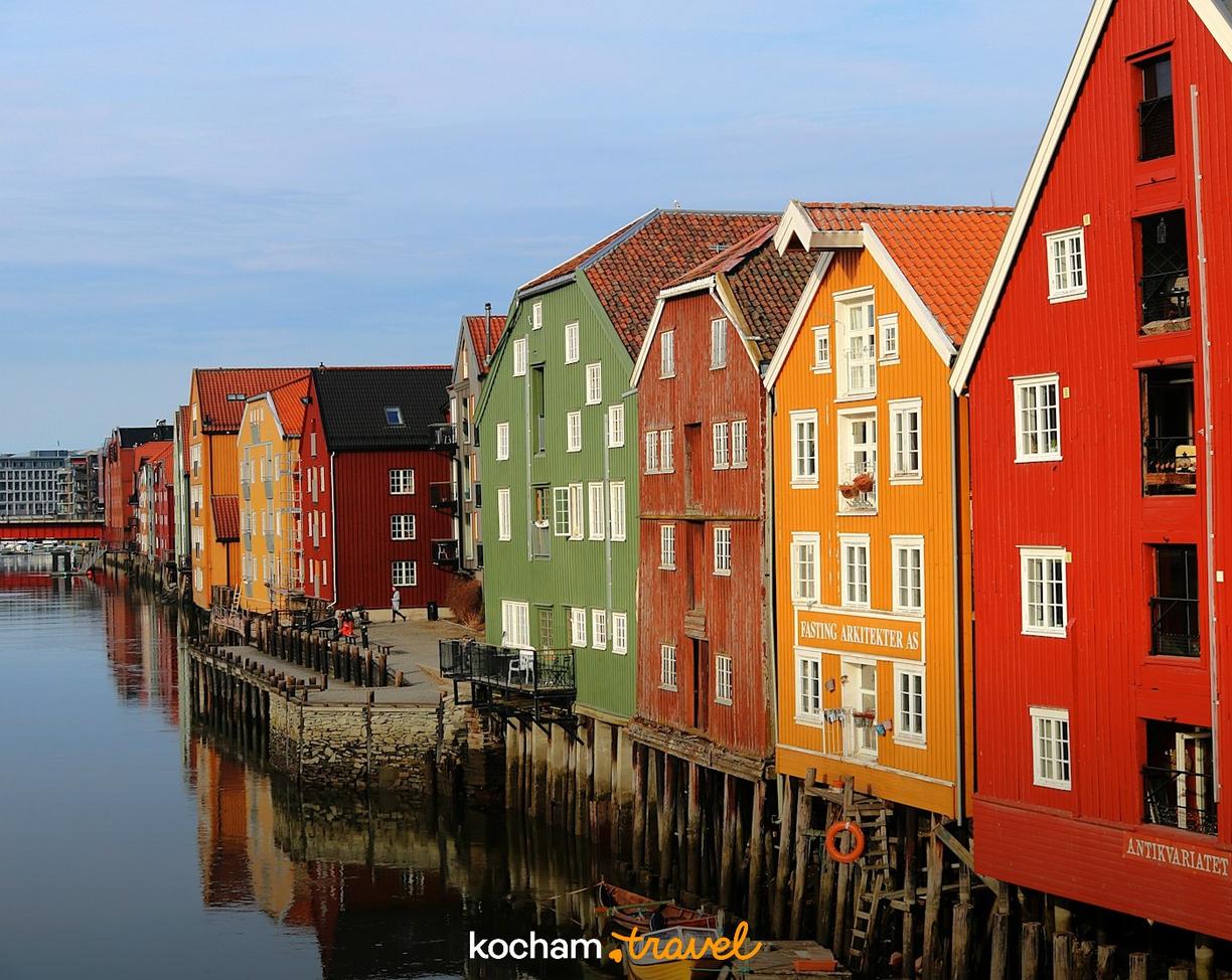 Kolorowe drewniane domy na palach nad rzeką Nidelva w Trondheim.
