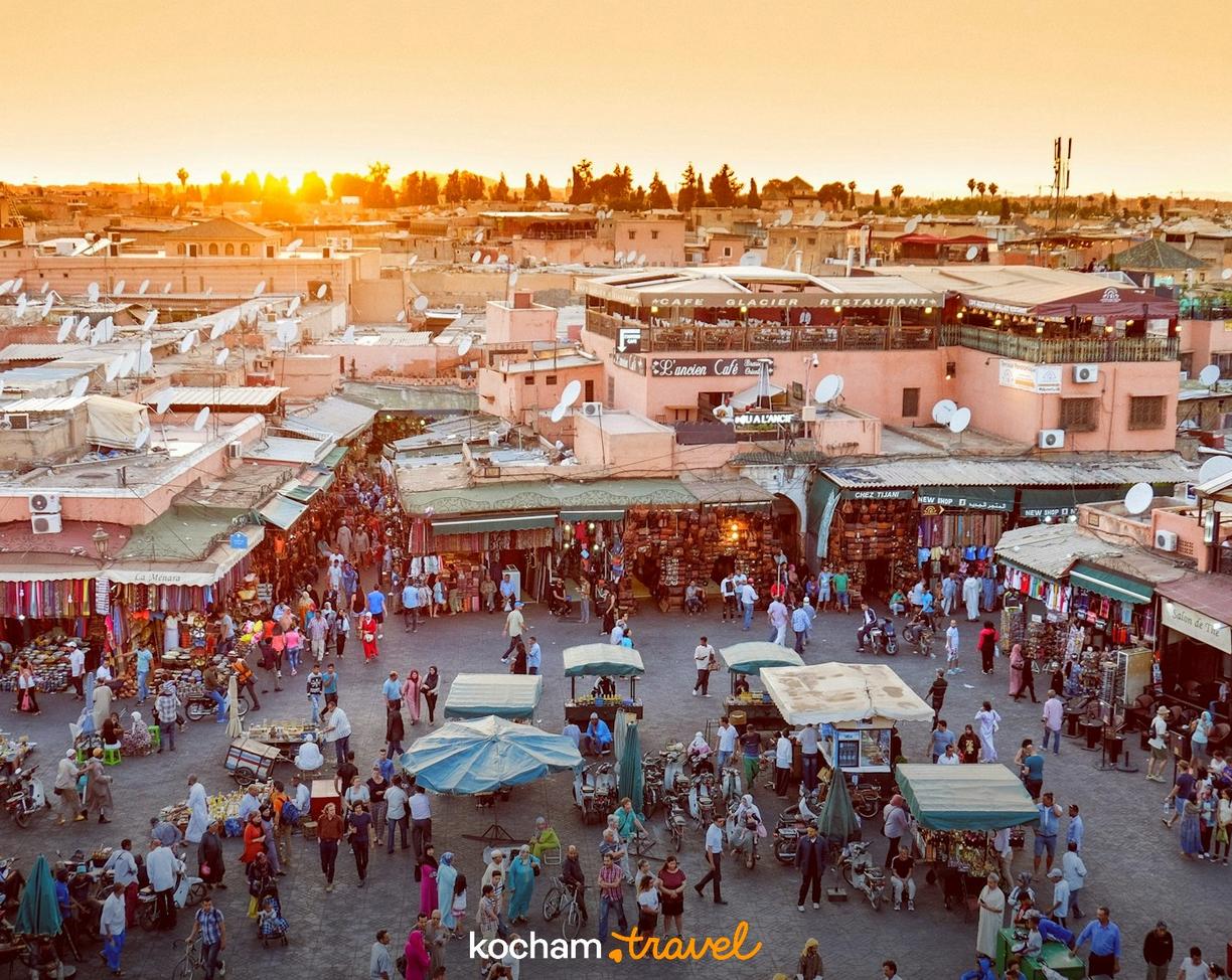 Tętniący życiem plac Jemaa el-Fna w Marrakeszu o zachodzie słońca.
