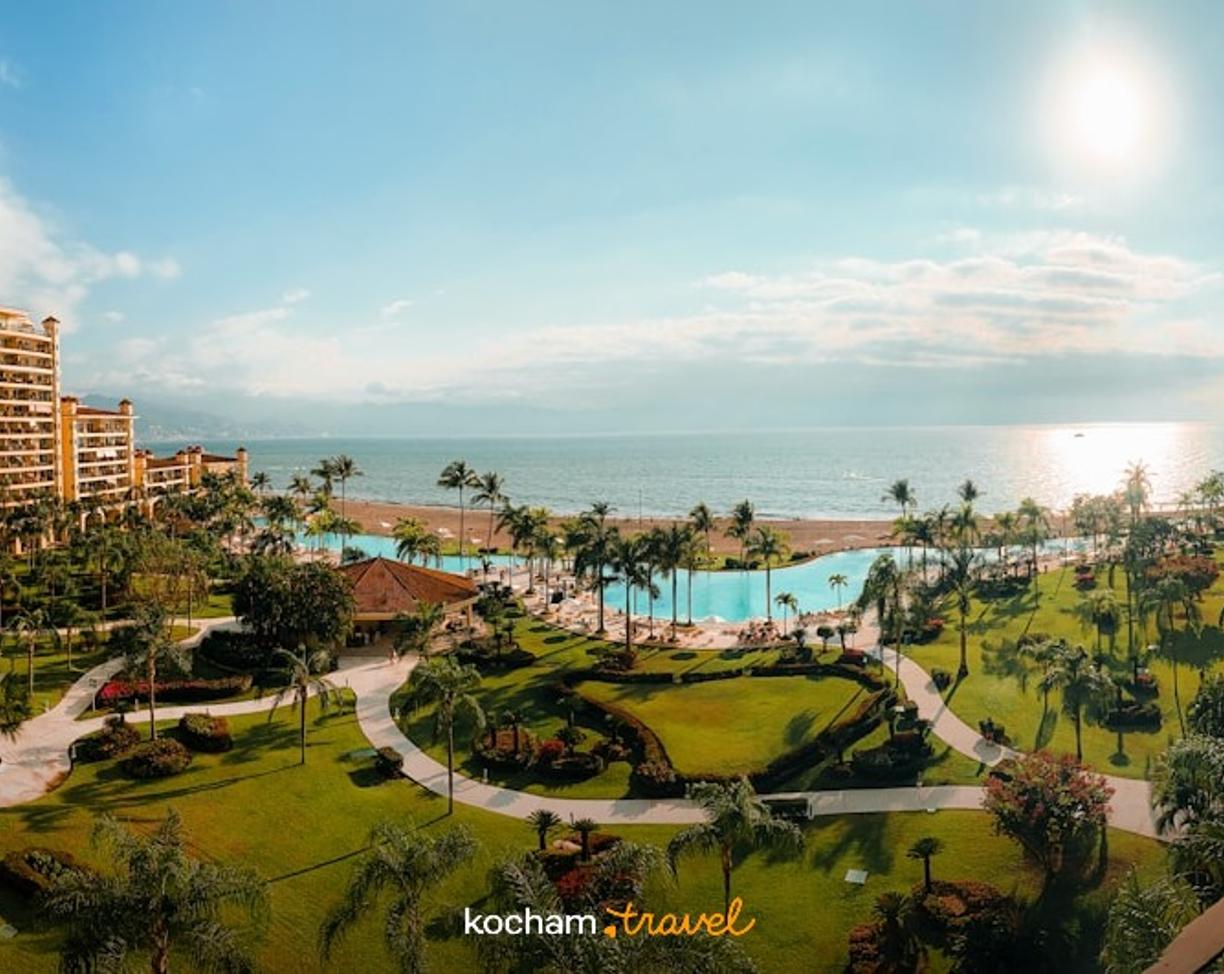 Panoramiczny luksusowy resort, zielone ogrody, basen, plaża, ocean.