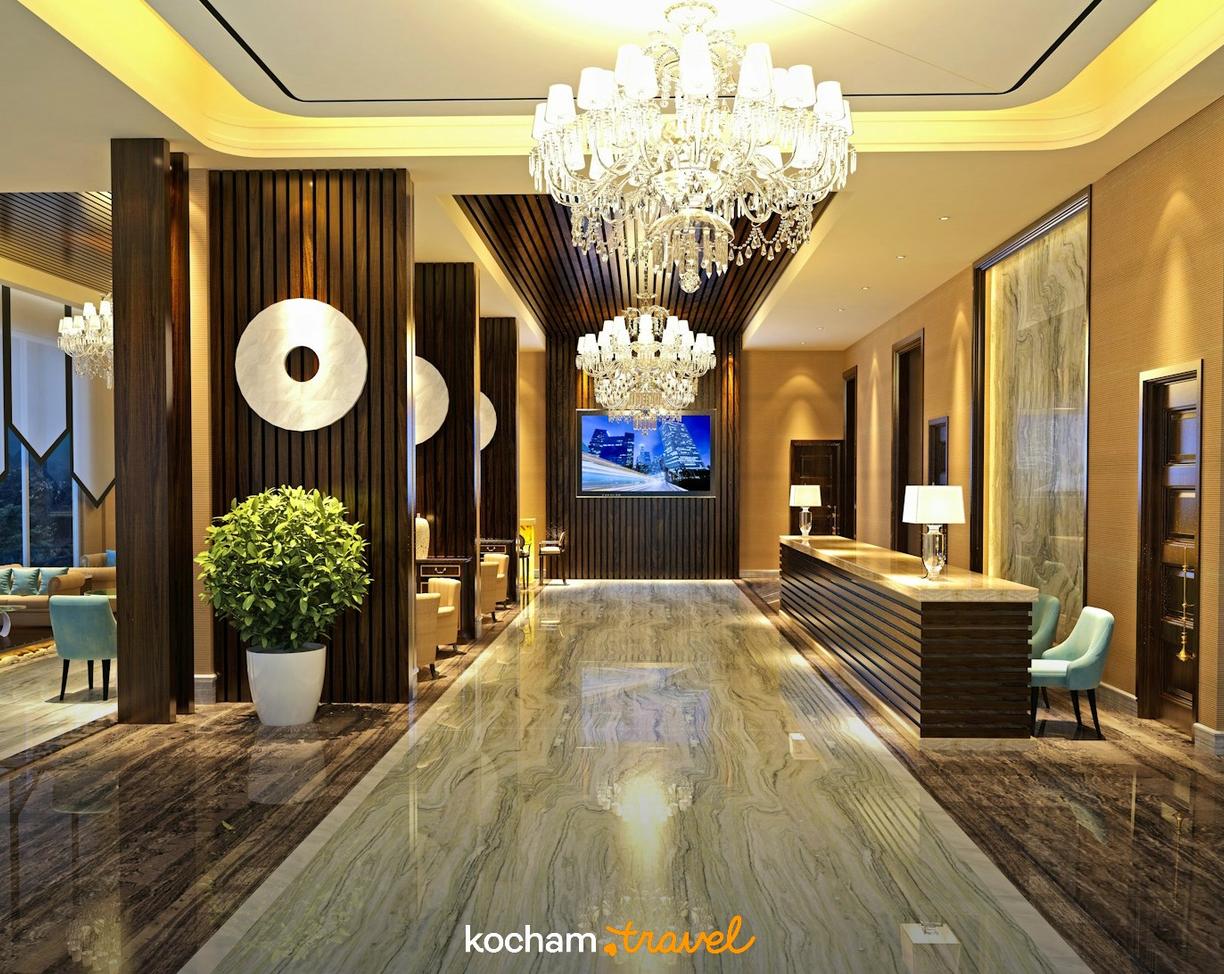 Elegancki hol hotelowy z lśniącym marmurem i kryształowymi żyrandolami.