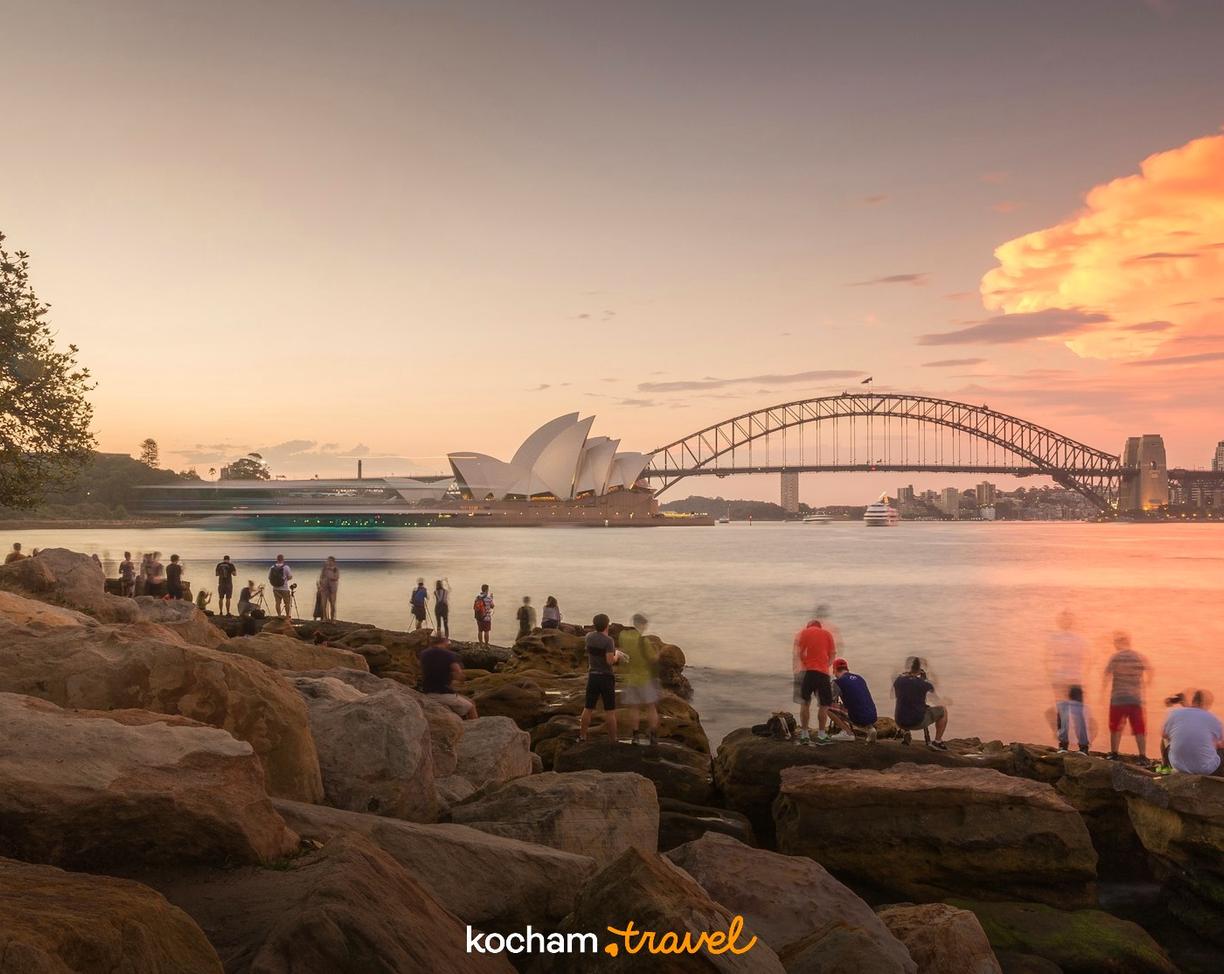 Fotografowie uwieczniający zachód słońca nad Operą i Mostem w Sydney.