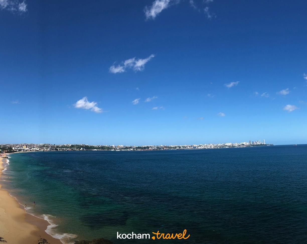 Złota plaża, turkusowy ocean i rozległa panorama miasta.