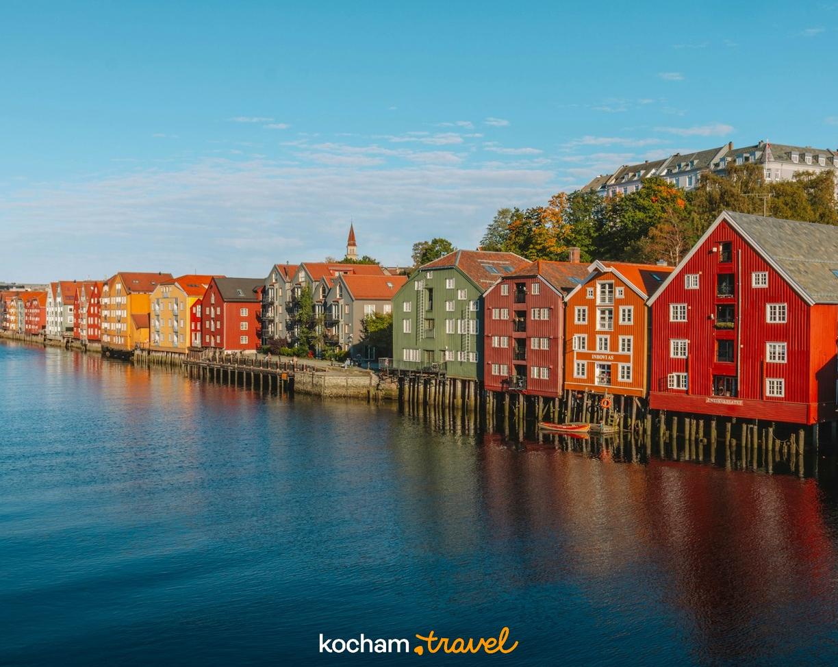 Kolorowe drewniane spichlerze nad rzeką Nidelva w Trondheim, Norwegia.