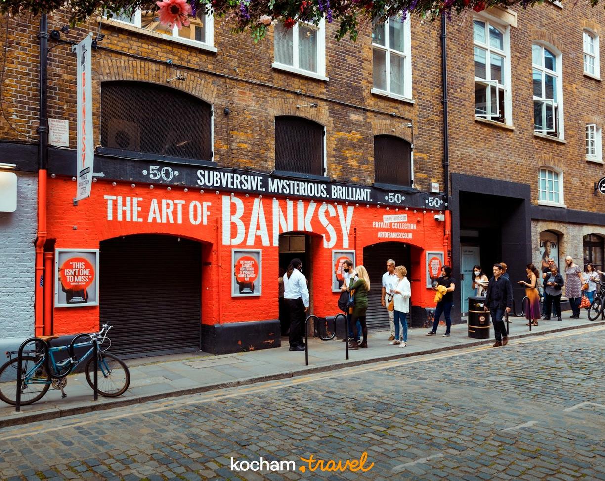 Ludzie przed wystawą The Art of Banksy na londyńskiej ulicy.