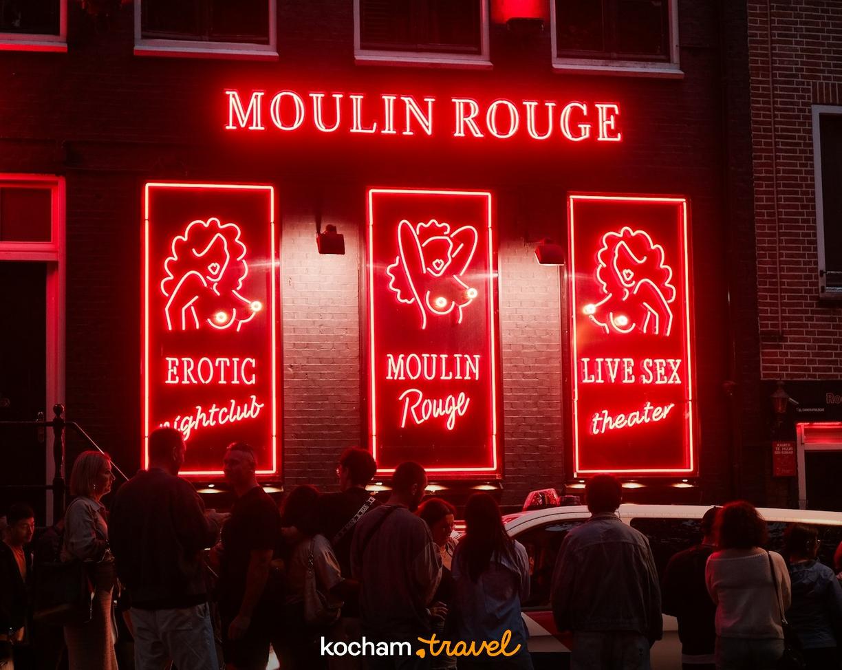 Czerwone neony Moulin Rouge i klubów nocnych w dzielnicy rozrywki.
