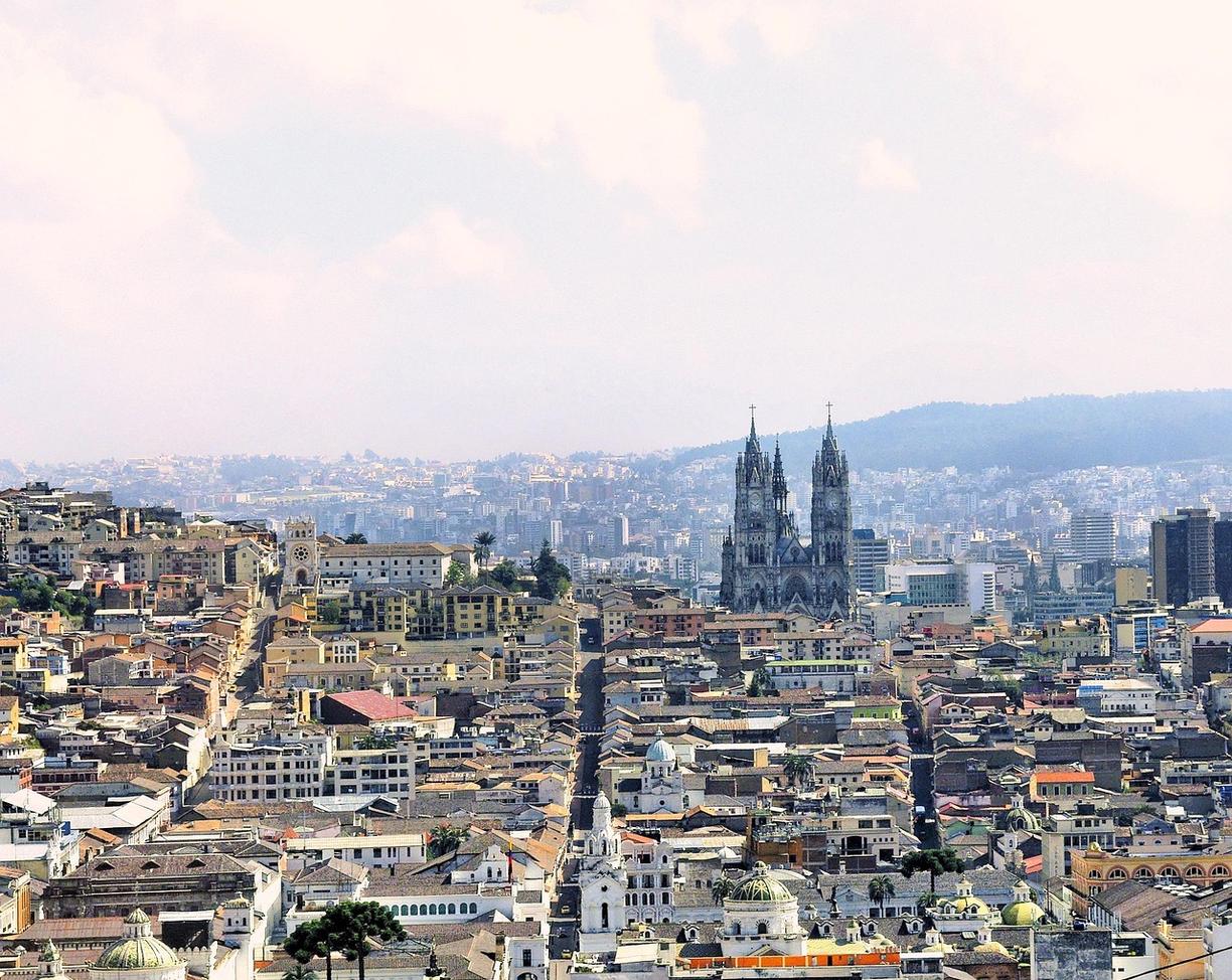 Panoramiczny widok na Quito z gotycką katedrą, starymi budynkami i górami.