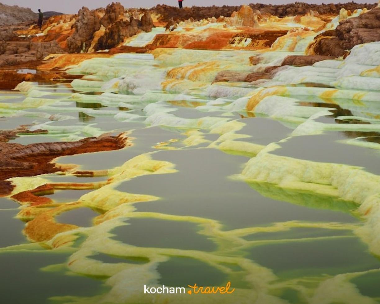 Kolorowy geotermalny krajobraz Dallol w Etiopii z mineralnymi basenami.