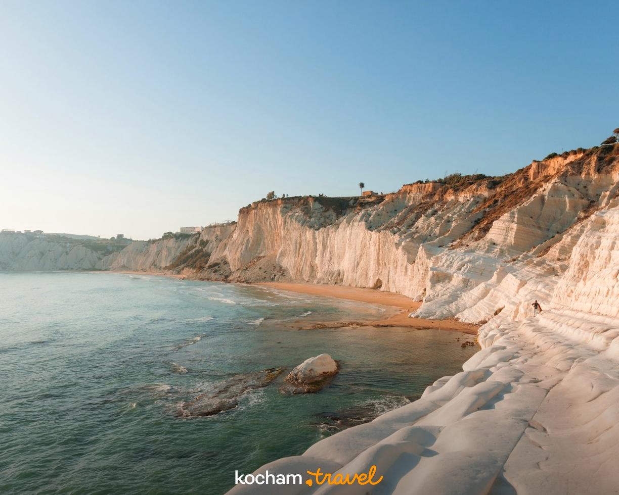Białe klify Scala dei Turchi, piaszczysta plaża i turkusowe morze.