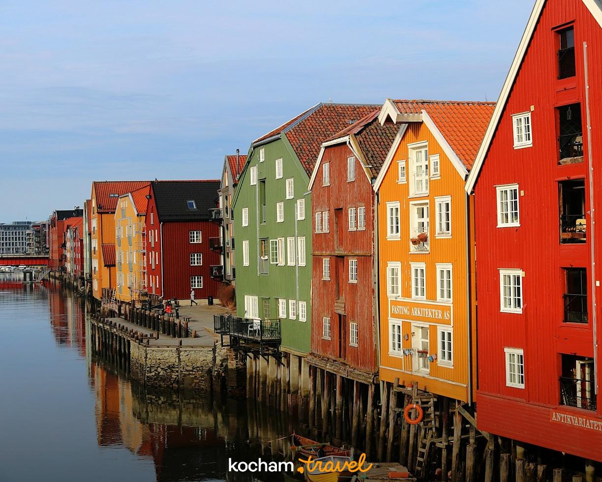 Kolorowe drewniane domy na palach nad rzeką Nidelva w Trondheim.