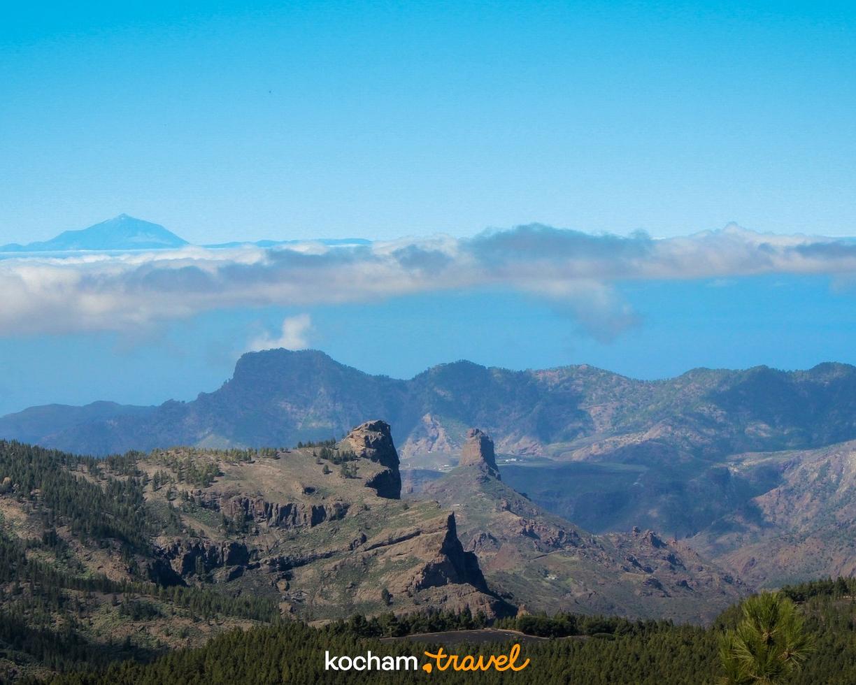 Słoneczny krajobraz Gran Canarii z Roque Nublo i wulkanem Teide.