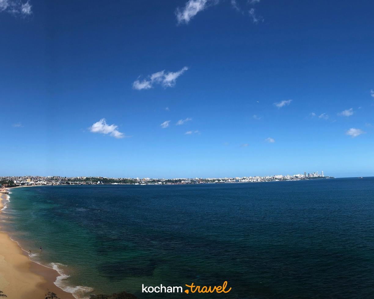 Złota plaża, turkusowy ocean i rozległa panorama miasta.