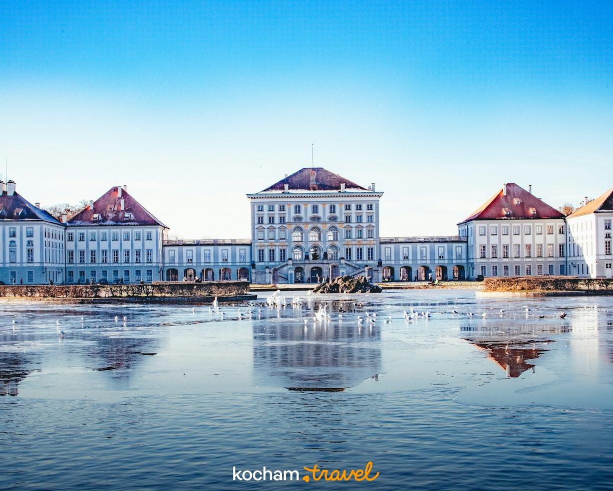 Zimowy Pałac Nymphenburg w Monachium, odbity w zamarzniętym kanale.
