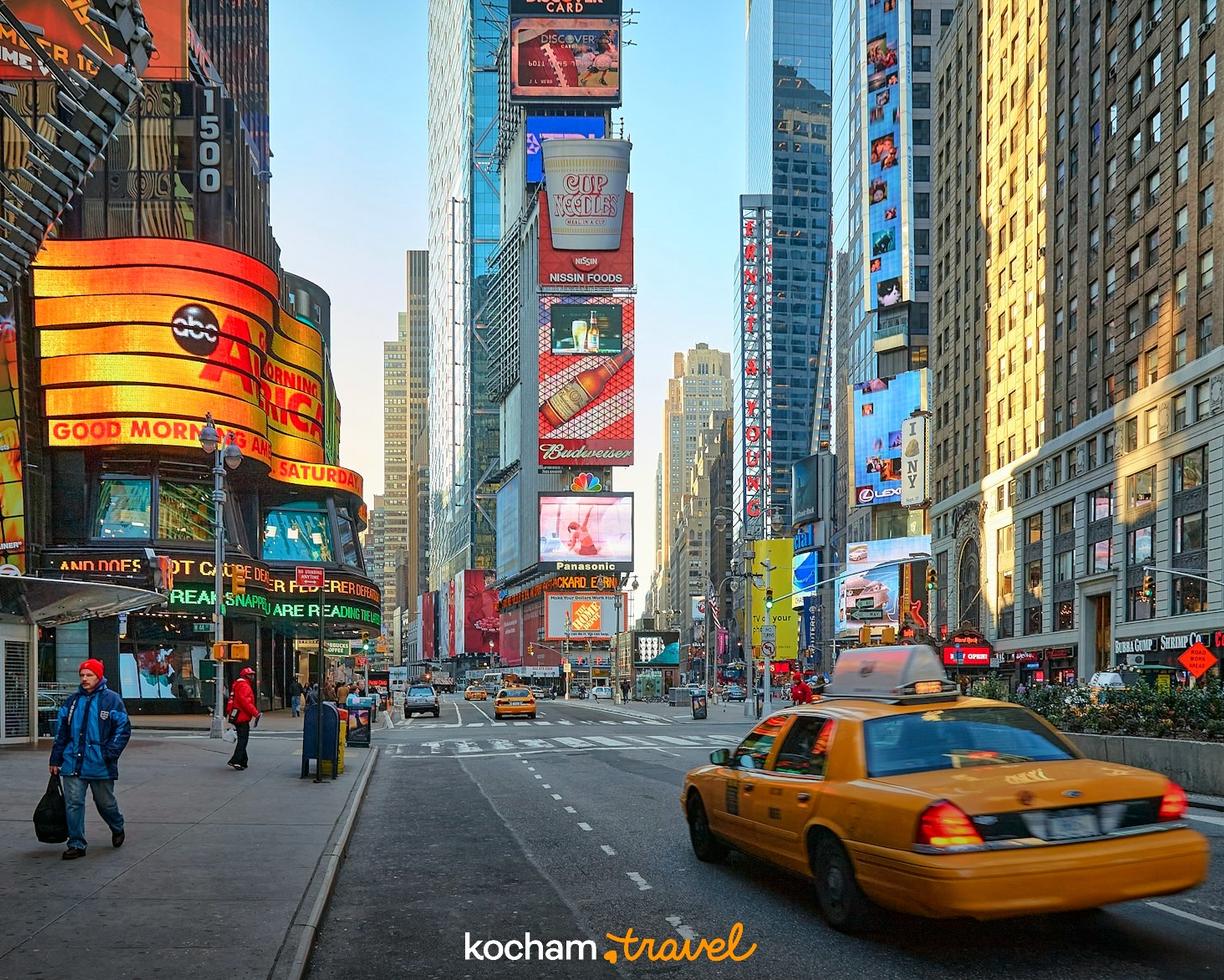 Ikoniczny Times Square w Nowym Jorku, jasne bilbordy i taksówka.