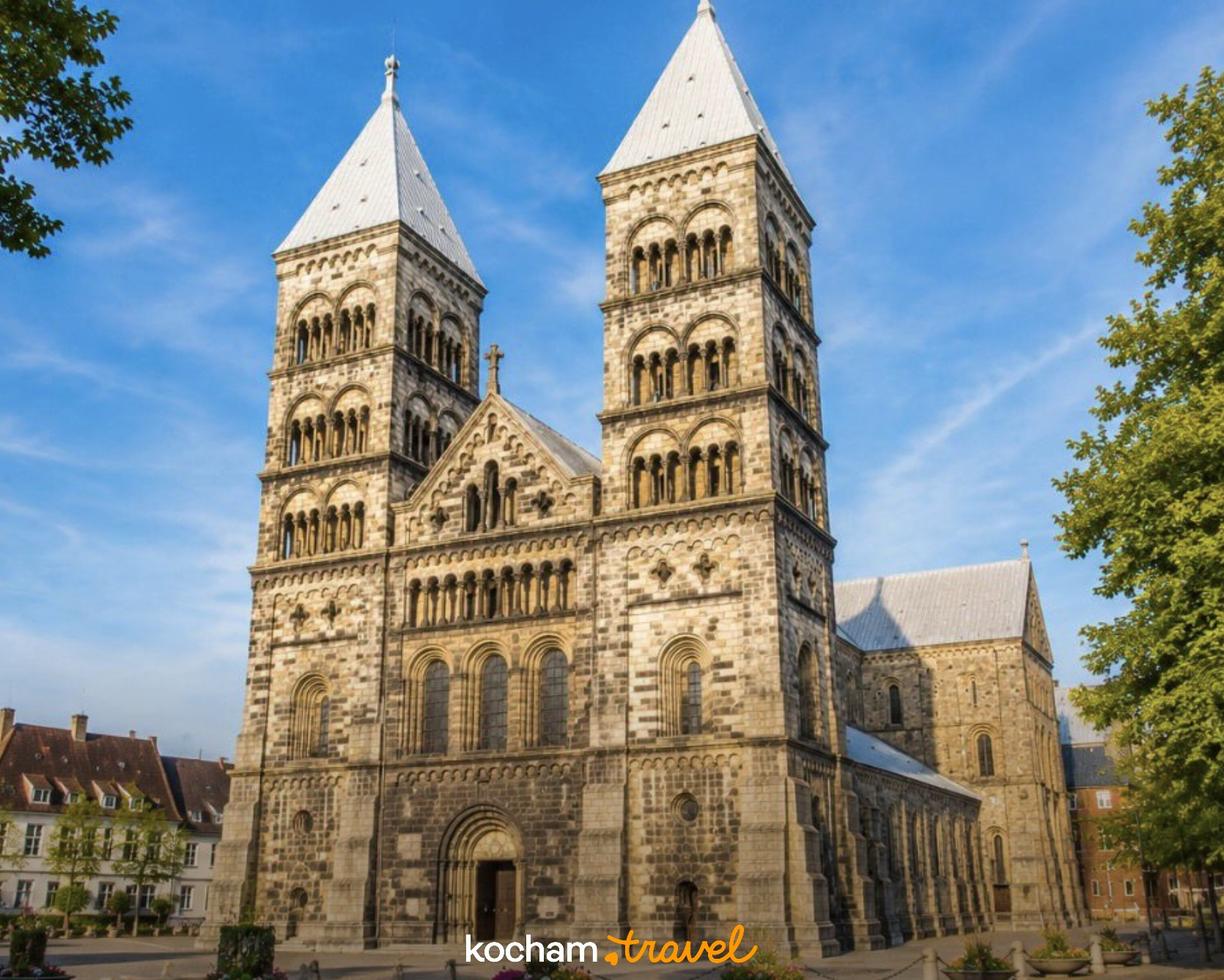 Romańska Katedra w Lund z imponującymi wieżami na tle błękitnego nieba.