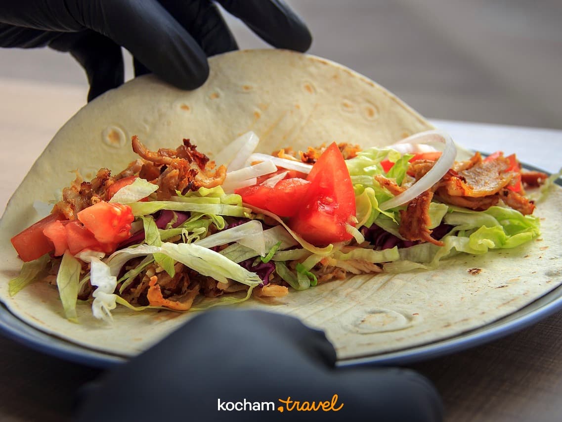 Świeży wrap kebab z mięsem, sałatą, pomidorem i cebulą