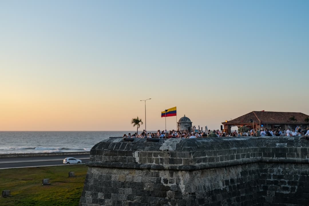Widok na kolumbijski fort, ludzi i ocean o zachodzie słońca.