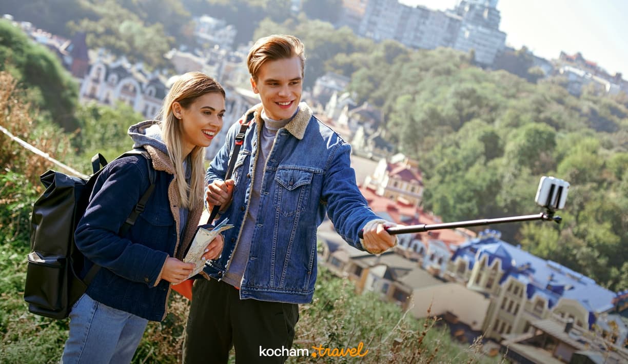 Młoda para turystów robi selfie z widokiem na miasto.