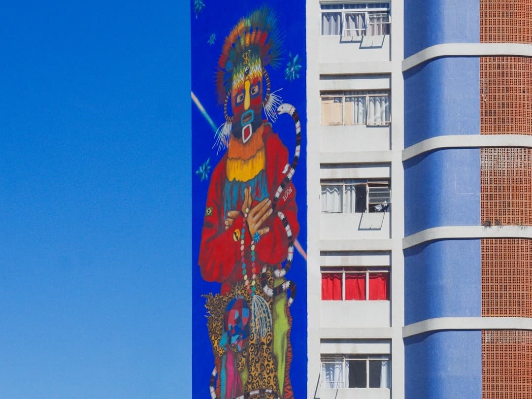 Wibrujący mural zamaskowanej postaci na fasadzie miejskiego budynku.