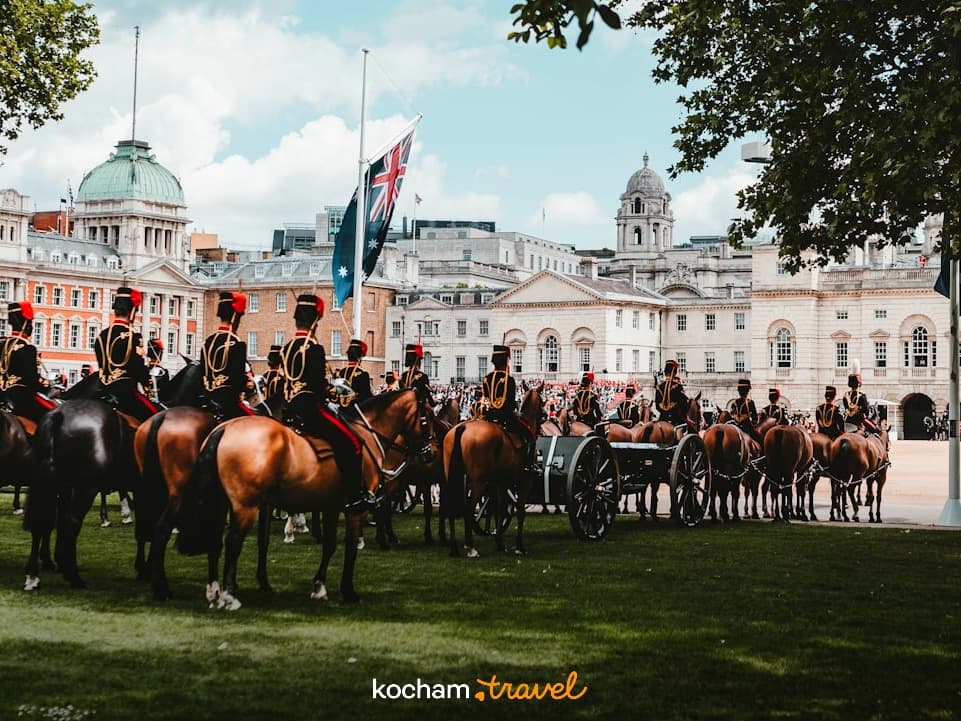 Kawalerzyści konni w ceremonialnych mundurach podczas parady w Londynie, zabytkowe budynki.