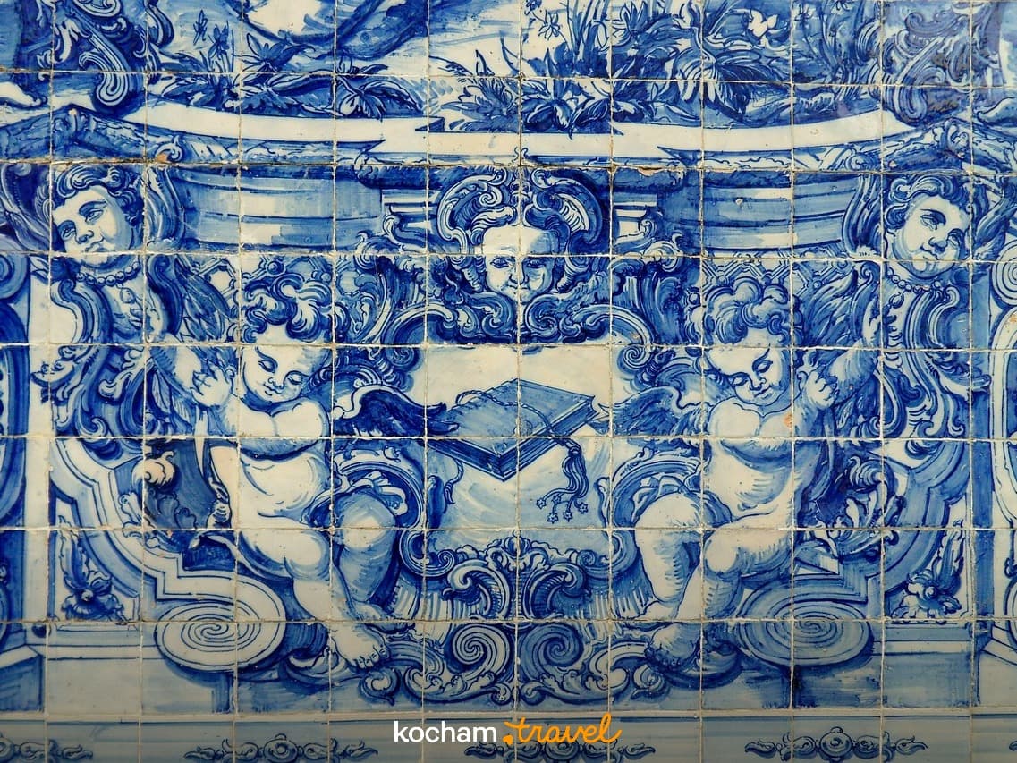 Ozdobne niebiesko-białe płytki azulejo z cherubinami i barokowymi wzorami.
