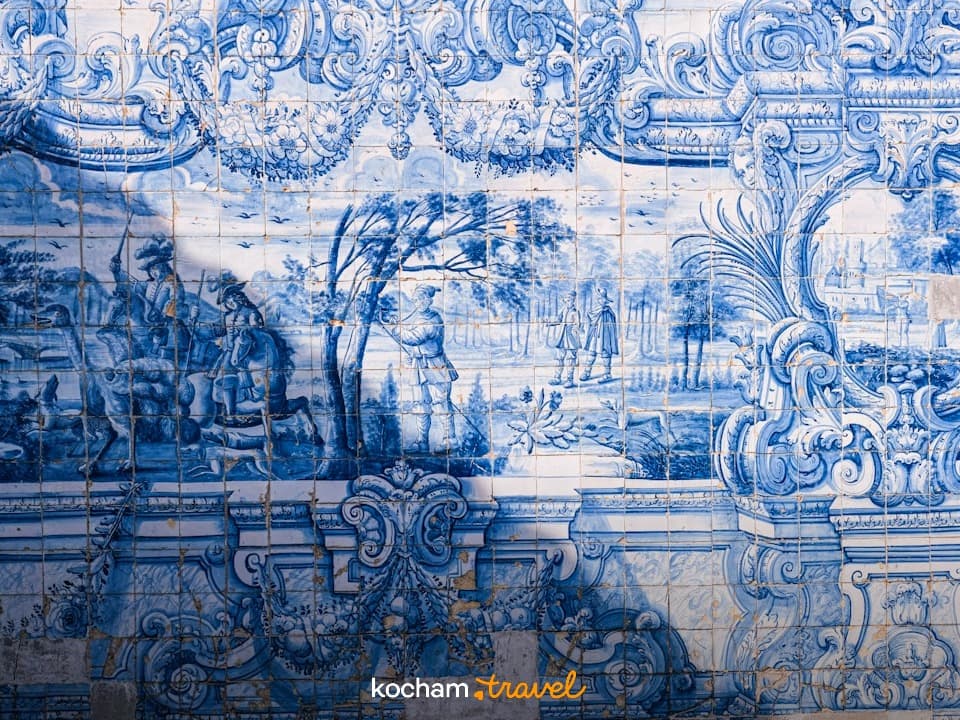 Szczegółowa niebiesko-biała mozaika z azulejos ze scenami historycznymi.