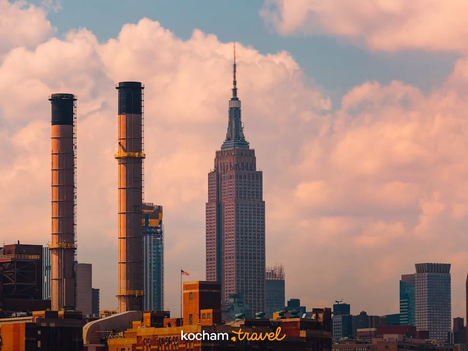 Nowojorski skyline z Empire State Building i kominami o zachodzie słońca.