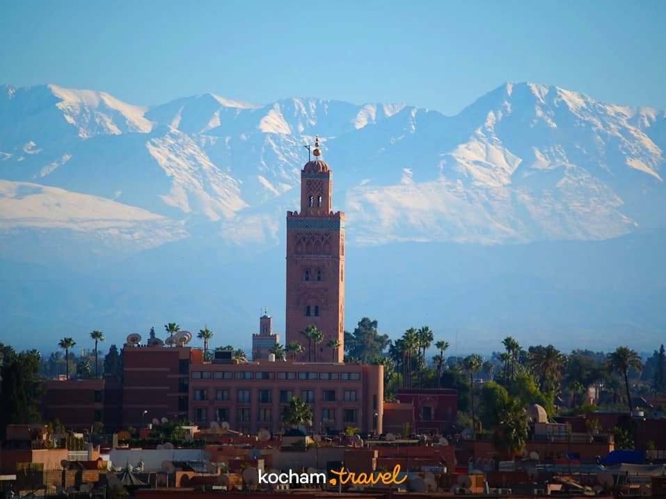 Słynny minaret Kutubija w Marrakeszu z ośnieżonymi Górami Atlas w tle.