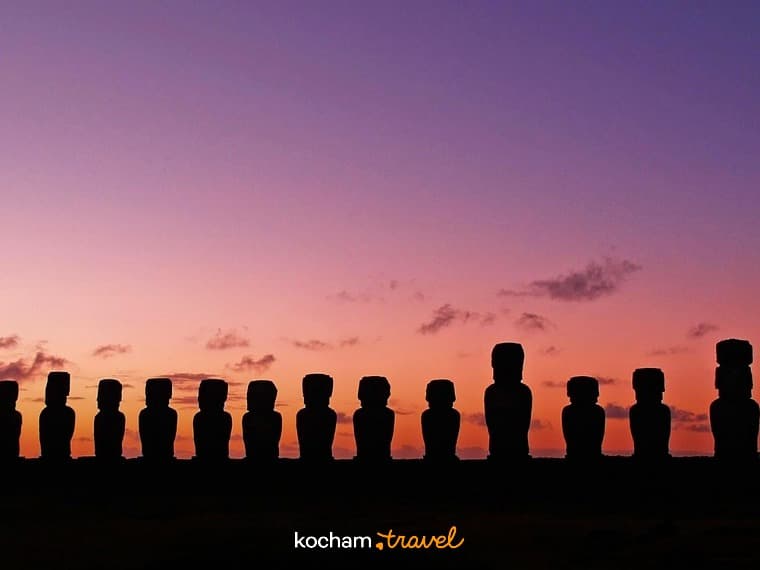 Panoramiczne sylwetki Moai o zachodzie słońca, Wyspa Wielkanocna, barwne niebo.