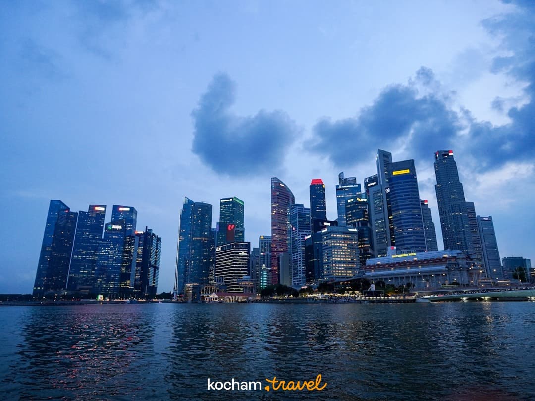 Wieczorna panorama Singapuru z drapaczami chmur i odbiciami w wodzie.
