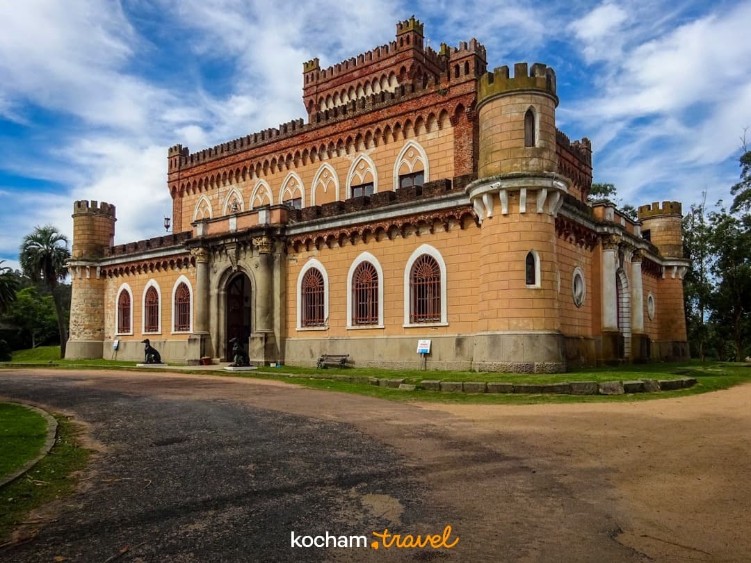 Historyczny budynek zamkowy z wieżami, pod błękitnym niebem.