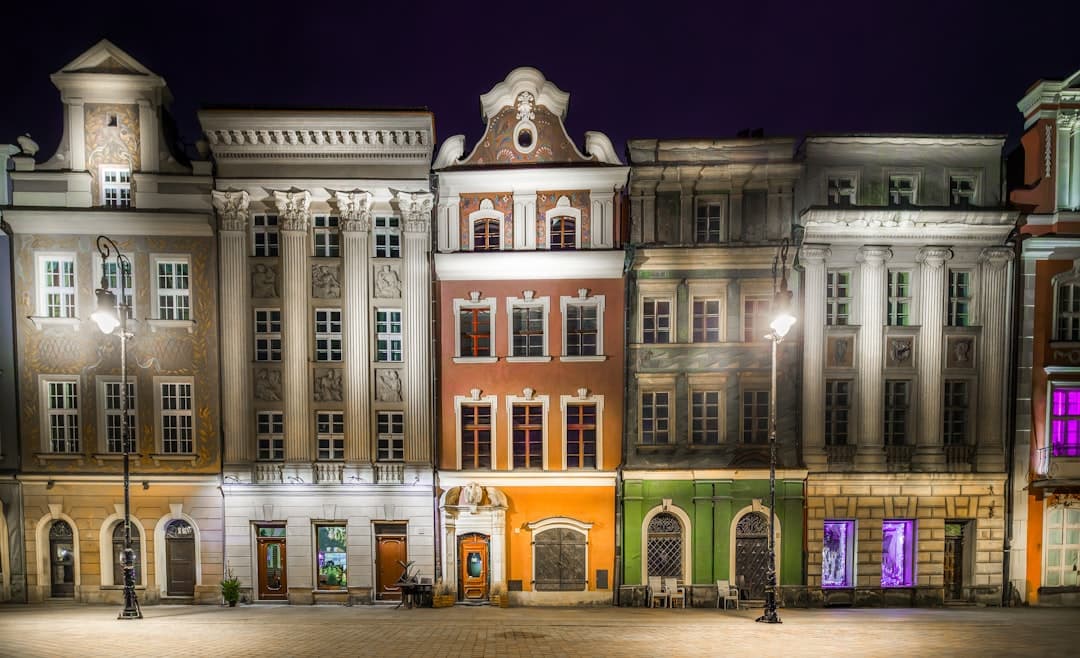 Kamieniczki na rynku nocą, oświetlone latarniami.