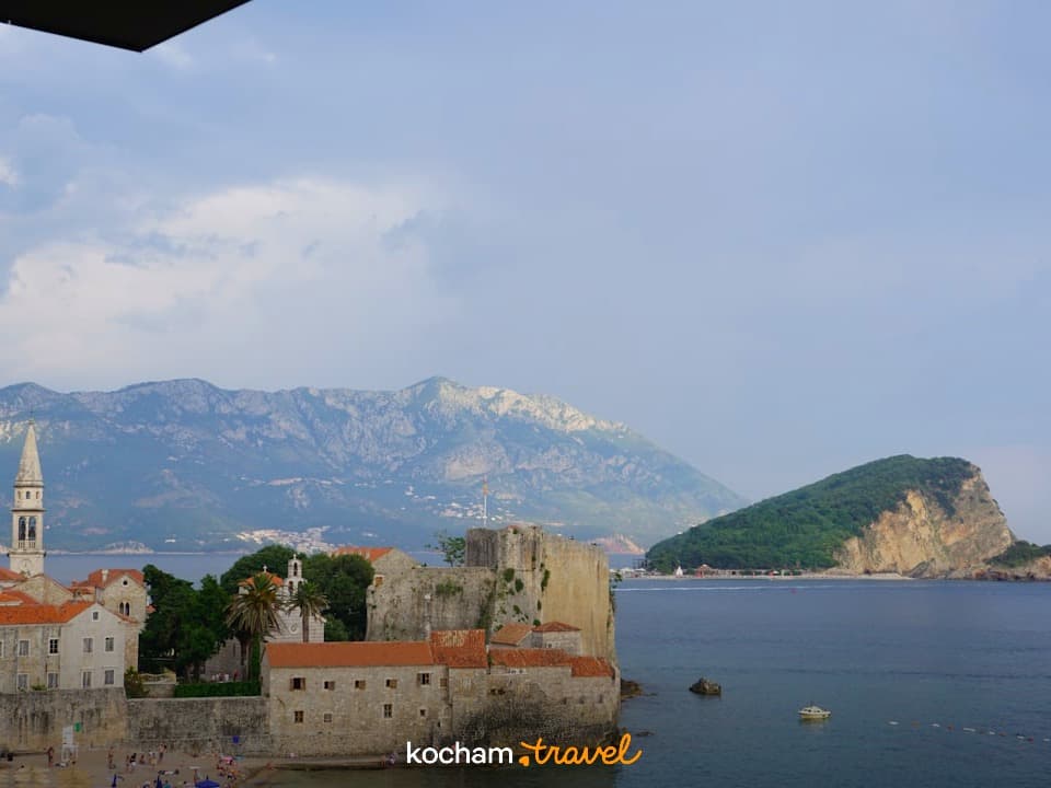 Stare Miasto Budva, wieża kościelna, mury obronne, morze, góry Czarnogóry.