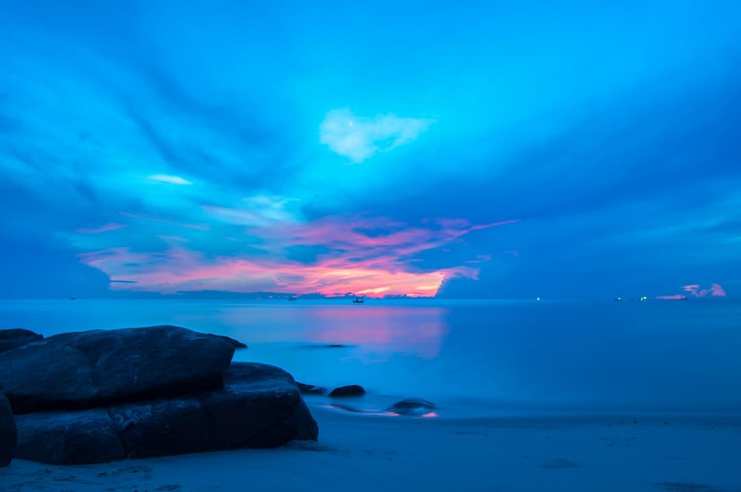 Tropikalny zachód słońca nad plażą w Blue Bay
