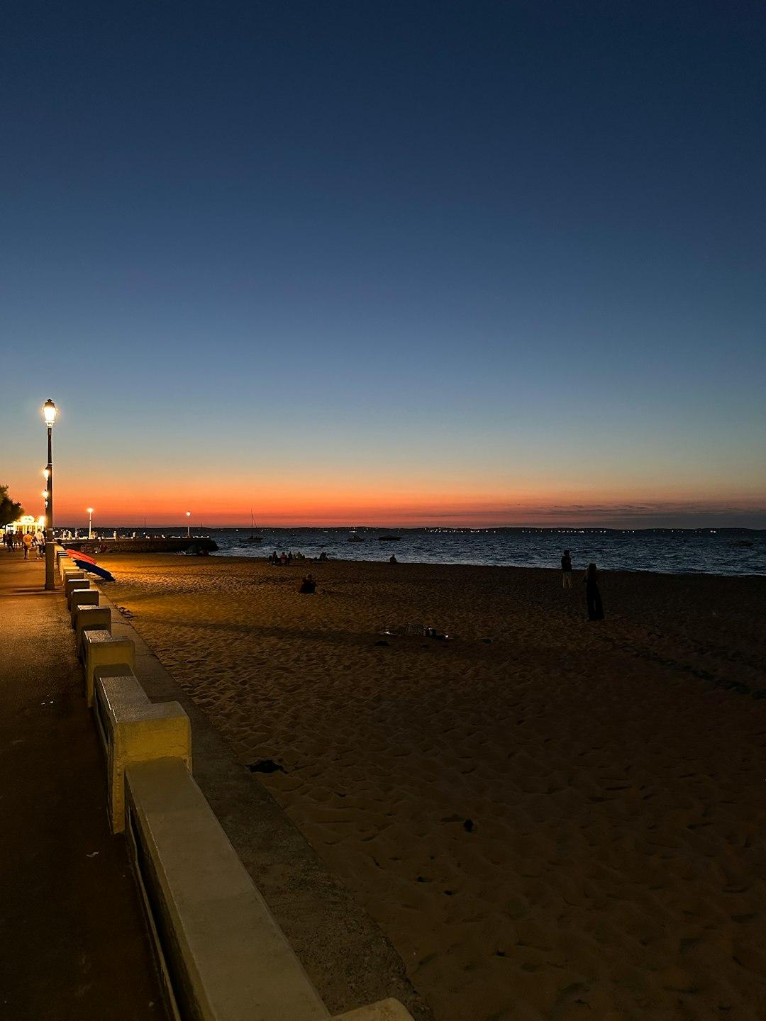 Zachód słońca na plaży w Barcelonie z relaksującymi się ludźmi