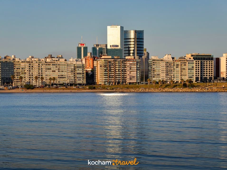 Panorama miasta Montevideo, wybrzeże, nowoczesne budynki, błękitna woda, odbicie słońca.