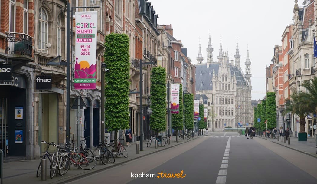 Zabytkowa ulica w Leuven, Belgia, z ratuszem i rowerami.