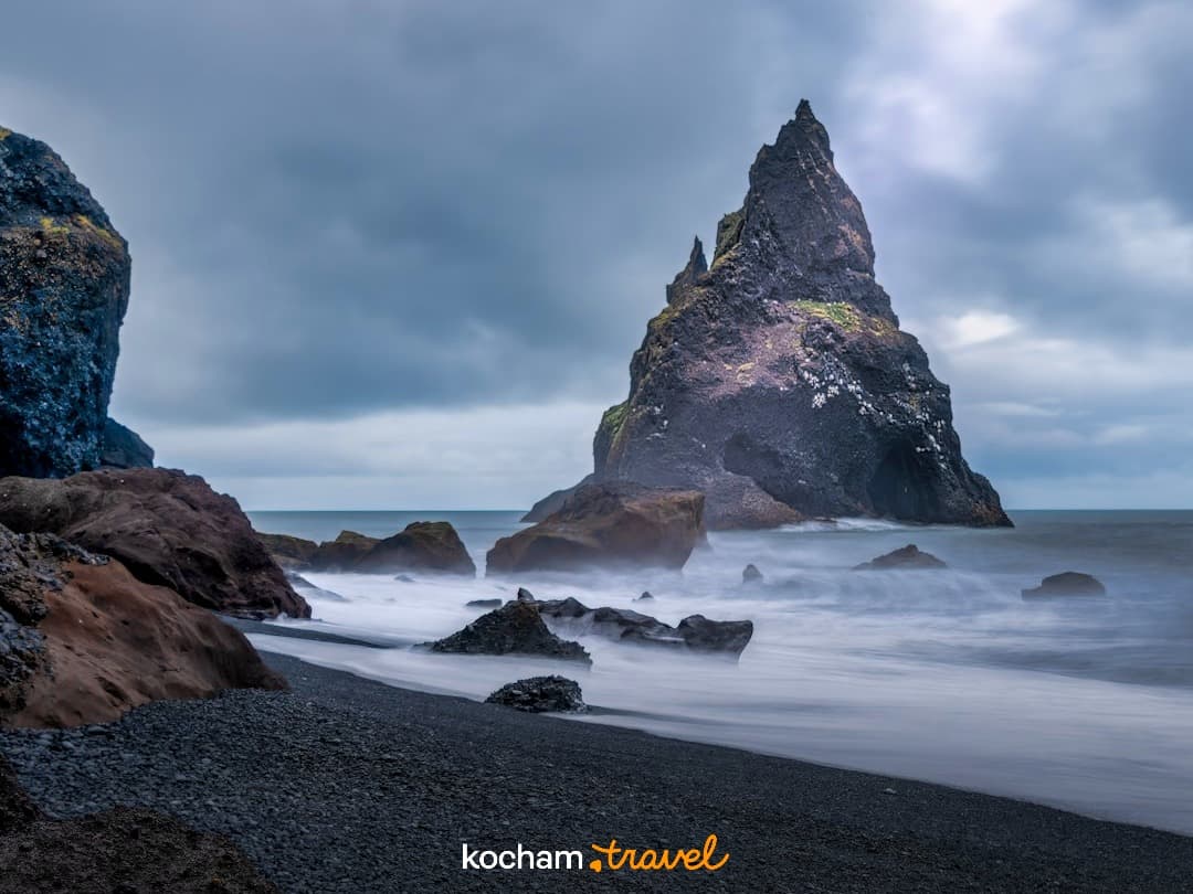 Czarne piaski Reynisfjara, skały Reynisdrangar, wzburzone morze, Islandia.