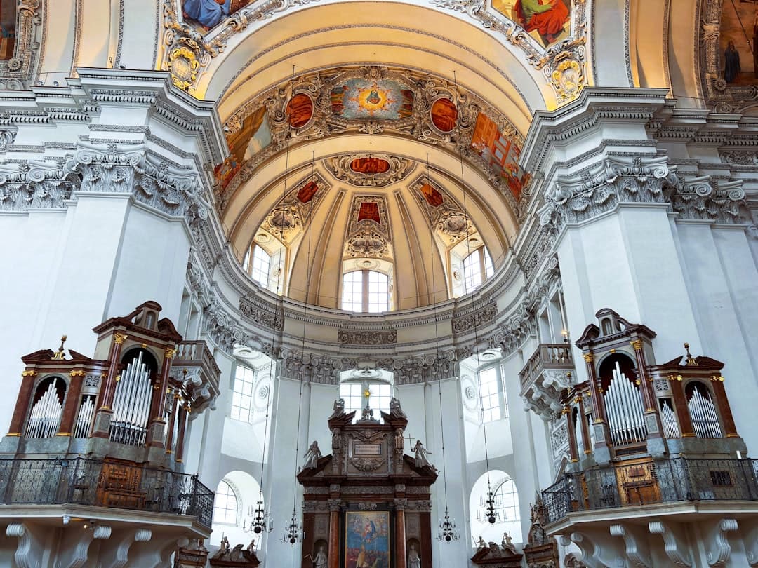 Barokowe wnętrze katedry w Salzburgu z ozdobnymi organami i freskami.