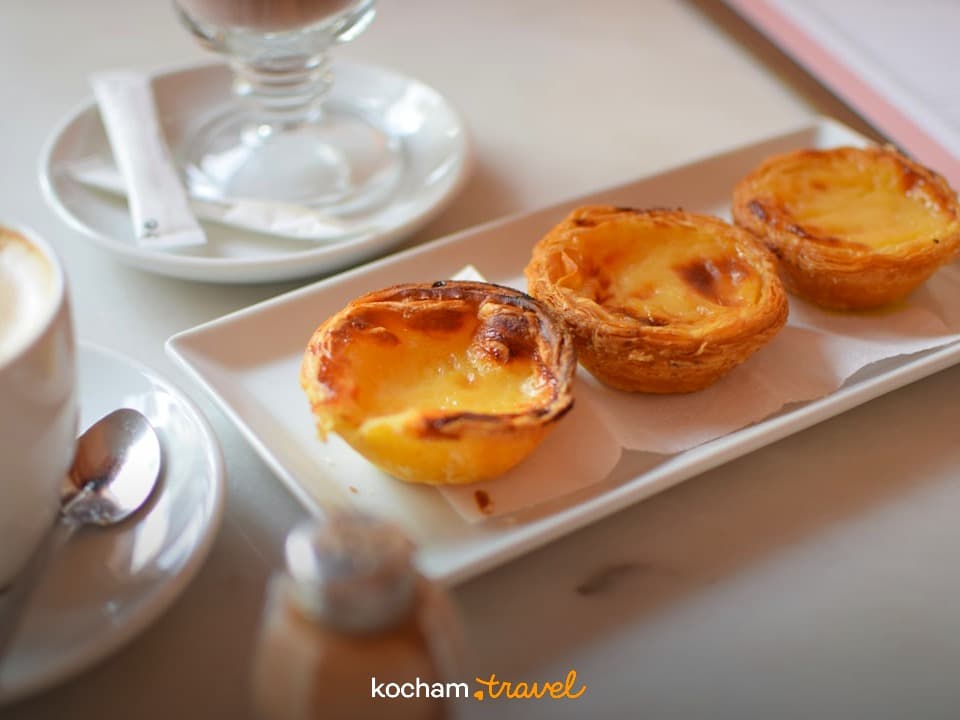 Pyszne portugalskie Pastéis de Nata i kawa na stole w kawiarni.